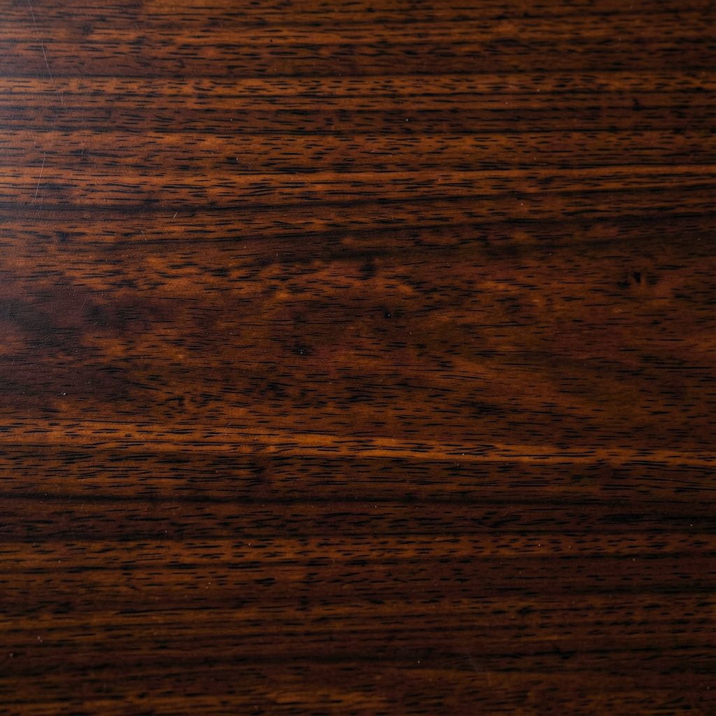Deep chocolate brown wood grain texture with warm highlights, calm and steady mood