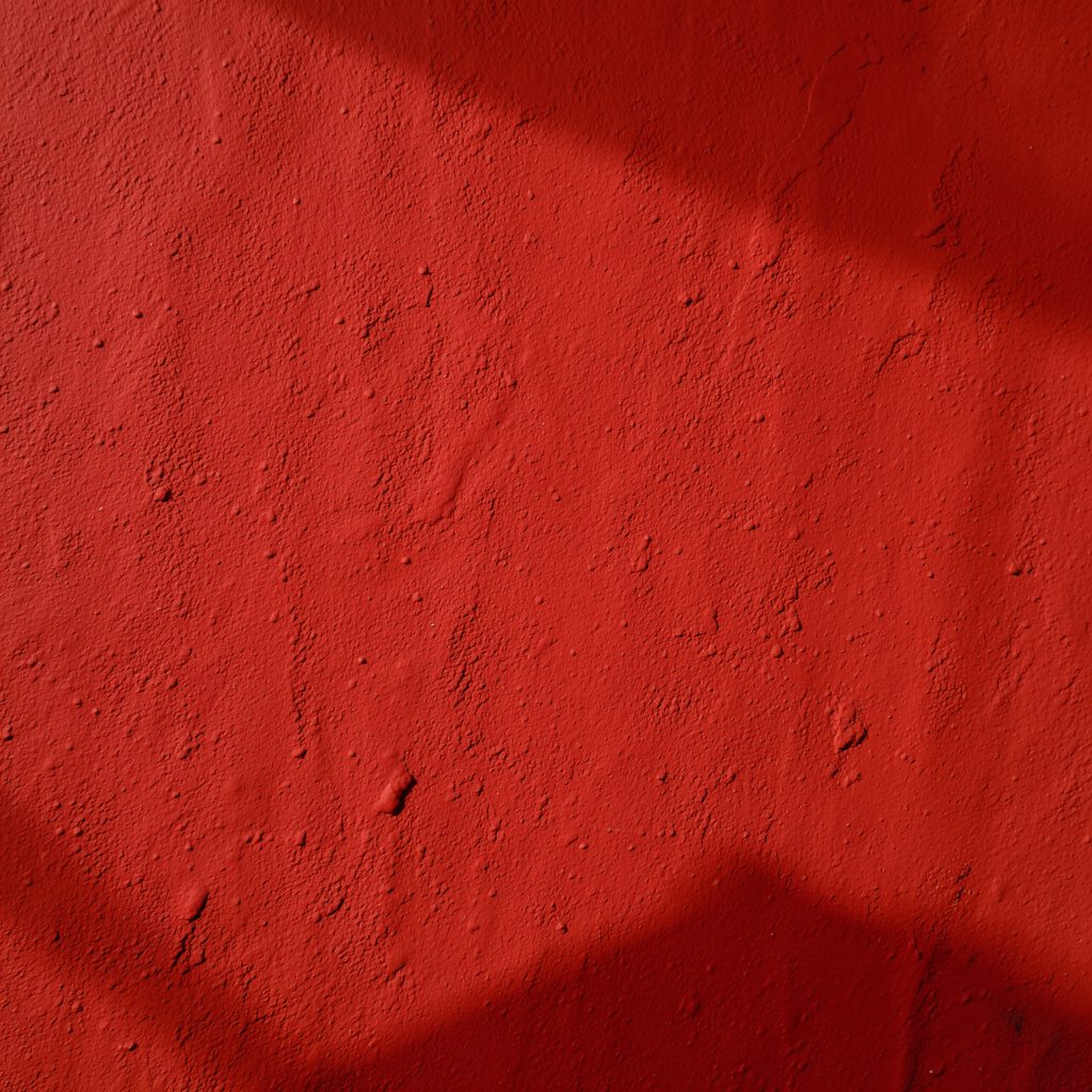 Warm brick red textured surface with subtle shadows, bold and inviting mood